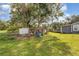 Backyard featuring a large chicken coop with surrounding green space and mature trees at 36725 Arcadia Ave, Myakka City, FL 34251