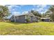 Charming single-story home with gray siding, metal roof, and well-maintained lawn and landscaping at 36725 Arcadia Ave, Myakka City, FL 34251
