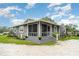 Charming home featuring a screened-in front porch, manicured landscaping, and a freshly painted exterior at 36725 Arcadia Ave, Myakka City, FL 34251