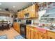 Charming kitchen with light wood cabinets, granite counters and black appliances at 36725 Arcadia Ave, Myakka City, FL 34251