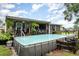 Backyard featuring an above ground pool, a covered porch and ample yard space, perfect for outdoor activities at 36725 Arcadia Ave, Myakka City, FL 34251