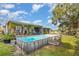 Backyard featuring an above ground pool, a covered porch and ample yard space, perfect for outdoor activities at 36725 Arcadia Ave, Myakka City, FL 34251