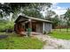 Exterior view of a well-maintained shed with an open workspace and gravel driveway at 36725 Arcadia Ave, Myakka City, FL 34251