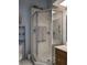 Corner shower with glass doors and marble tiling, complemented by chrome fixtures and accessories at 39650 Us Hwy 19 N, Tarpon Springs, FL 34689