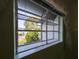 Interior view of a window with a green painted frame overlooking the front yard and neighborhood at 39650 Us Hwy 19 N, Tarpon Springs, FL 34689