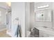 Well-lit bathroom featuring vanity mirror with lights, bathtub and blue towels at 400 E Jean St, Tampa, FL 33604