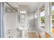 Bright bathroom with a pedestal sink, shower, natural light from windows and a clean, neutral design at 400 E Jean St, Tampa, FL 33604