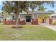 Charming two-story home with white siding, red brick accents, front porch, and covered carport at 400 E Jean St, Tampa, FL 33604