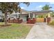 Charming two-story home with white siding, red brick accents, front porch, and covered carport at 400 E Jean St, Tampa, FL 33604