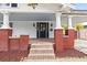 Charming front porch with red brick base, stone steps, and covered ceiling at 400 E Jean St, Tampa, FL 33604