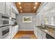 Bright kitchen with a wood ceiling, granite countertops, stainless appliances, and white cabinetry at 400 E Jean St, Tampa, FL 33604