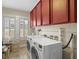 Laundry room with front load washer and dryer, red cabinets, and tile floors at 400 E Jean St, Tampa, FL 33604