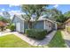Charming home with attached garage, blue siding, lush landscaping and a well-manicured lawn at 4418 Pine Meadow Ct, Tampa, FL 33624
