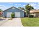 Exterior view of home with attached two-car garage, driveway, and well-maintained landscaping at 4418 Pine Meadow Ct, Tampa, FL 33624