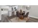 Modern kitchen features white cabinets, bar seating and a dining area with four chairs at 4418 Pine Meadow Ct, Tampa, FL 33624