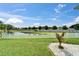 Tranquil backyard with lush lawn and views of the serene pond behind a white picket fence at 449 Bahama Grande Blvd, Apollo Beach, FL 33572