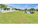 Lush green backyard with pond view, complemented by a pristine white fence at 449 Bahama Grande Blvd, Apollo Beach, FL 33572