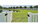 View of a well-maintained backyard with a tranquil pond, accessible through a white picket gate at 449 Bahama Grande Blvd, Apollo Beach, FL 33572