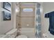 Bright bathroom featuring a tiled shower-tub combination, decorative nautical wall art, and white fixtures at 449 Bahama Grande Blvd, Apollo Beach, FL 33572