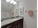 Elegant bathroom vanity featuring granite countertops, a large mirror, and ample lighting at 449 Bahama Grande Blvd, Apollo Beach, FL 33572