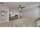 Airy bedroom with a leafy comforter, dresser, and fan with light-colored carpet and an archway to another room at 449 Bahama Grande Blvd, Apollo Beach, FL 33572