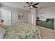 Bedroom with a leafy comforter and a dresser. There are doorways to a closet and hallway, all with light colors at 449 Bahama Grande Blvd, Apollo Beach, FL 33572