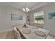 Elegant dining room with a decorative cabinet, modern chandelier, and outdoor views at 449 Bahama Grande Blvd, Apollo Beach, FL 33572