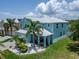 Beautiful two-story blue home with lush tropical landscaping and a paver driveway at 449 Bahama Grande Blvd, Apollo Beach, FL 33572