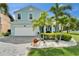 Beautifully landscaped two-story home with a two-car garage and vibrant turquoise exterior paint at 449 Bahama Grande Blvd, Apollo Beach, FL 33572