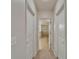 Hallway view with access to bathroom, featuring neutral decor, carpeted floor and paneled doors at 449 Bahama Grande Blvd, Apollo Beach, FL 33572