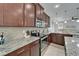 Modern kitchen includes stainless steel appliances, granite countertops, mosaic backsplash, and wood cabinetry at 449 Bahama Grande Blvd, Apollo Beach, FL 33572