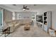 Open living space featuring a sectional sofa, ceiling fan, and entertainment center at 449 Bahama Grande Blvd, Apollo Beach, FL 33572