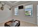 Bright living room with a black leather ottoman, TV and nature-themed decor for relaxation at 449 Bahama Grande Blvd, Apollo Beach, FL 33572