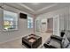 Well-lit living room featuring a black leather sofa, tray ceiling and large windows at 449 Bahama Grande Blvd, Apollo Beach, FL 33572