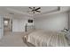 Spacious main bedroom featuring neutral decor, tray ceiling, ceiling fan, and ensuite bathroom access at 449 Bahama Grande Blvd, Apollo Beach, FL 33572