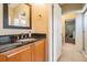Bathroom with granite countertop, wooden cabinets, and a decorative mirror at 5029 Camberley Ln, Oldsmar, FL 34677