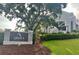 Community entrance sign with a modern building in the background, showcasing landscaping and design at 5029 Camberley Ln, Oldsmar, FL 34677