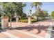 Community entrance featuring brick pavers, pillars, decorative lighting, and lush landscaping at 5029 Camberley Ln, Oldsmar, FL 34677