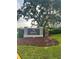 Entrance to Ardea Country Club featuring a well-maintained sign, landscaping and mature trees at 5029 Camberley Ln, Oldsmar, FL 34677
