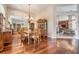 Formal dining room with hardwood floors, a mirrored wall, a large chandelier, and a view into the kitchen at 5029 Camberley Ln, Oldsmar, FL 34677