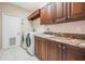 Laundry room has washer, dryer, sink, cabinets, and granite countertop at 5029 Camberley Ln, Oldsmar, FL 34677
