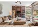 Cozy living room with built-in shelving, a fireplace, comfortable seating, neutral colors, and backyard views at 5029 Camberley Ln, Oldsmar, FL 34677