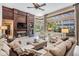 Comfortable living room with a fireplace, built-in shelving, lots of natural light, and views of the screened-in pool at 5029 Camberley Ln, Oldsmar, FL 34677