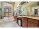 Bright main bathroom with dual sink vanity, soaking tub, and shuttered windows at 5029 Camberley Ln, Oldsmar, FL 34677