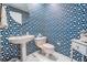 Charming powder room with eye-catching seashell patterned wallpaper, pedestal sink, and white tile flooring at 5029 Camberley Ln, Oldsmar, FL 34677