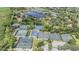 Aerial view of tennis courts, lush landscaping, and surrounding residential buildings with lake view at 5029 Camberley Ln, Oldsmar, FL 34677