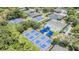 Aerial view of tennis and pickleball courts surrounded by lush greenery and shade canopies at 5029 Camberley Ln, Oldsmar, FL 34677