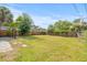 Large grassy backyard enclosed by a wooden fence and mature trees at 5622 Tangerine S Ave, Gulfport, FL 33707