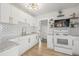 Modern kitchen featuring white cabinets, a gold faucet, subway tile backsplash and stainless-steel appliances, stylish and functional at 5622 Tangerine S Ave, Gulfport, FL 33707