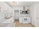 Bright kitchen showcasing white cabinets, gold hardware, subway tile, and stainless-steel appliances, offering modern convenience at 5622 Tangerine S Ave, Gulfport, FL 33707